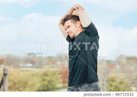 Caucasian man in sportswear stretching armpits and arms before exercising, doing flexible exercises, and warming up Caucasian man in sportswear stretching armpits and arms before exercising, doing flexible exercises, and warming up 96713532