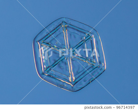 Snowflake on smooth gradient background. Macro photo of real snow crystal on glass surface. This is small snowflake crystal with unusual pattern 96714397