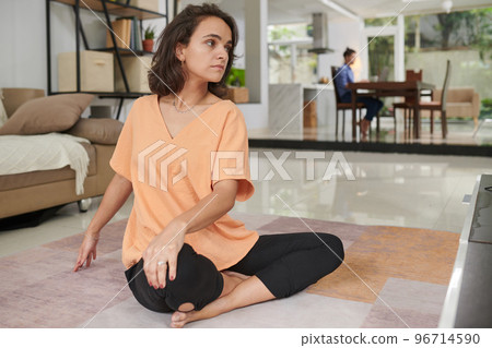 Young woman doing twist yoga pose when exercising at home 96714590