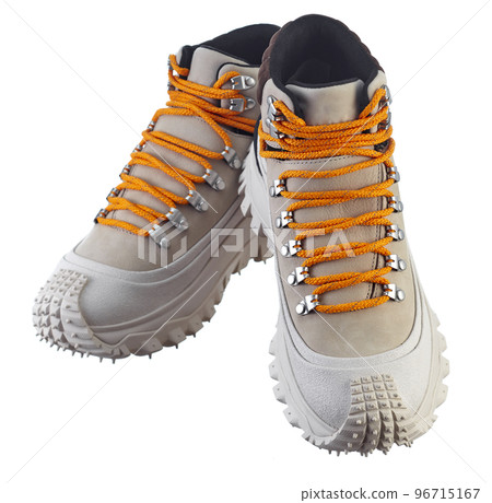 Front view of a beautiful pair of beige suede winter boots with orange alpine lazing on a massive anti-slip sole, isolated on a white background. 96715167