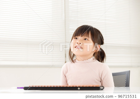 一個女孩的微笑學生在珠算教室裡學習。培養樂趣、抱負和動力的教育形象。 一個女孩的微笑學生在珠算教室裡學習。培養樂趣、抱負和動力的教育形象。 96715531