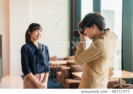 Male photographer taking a portrait of a woman 96717477