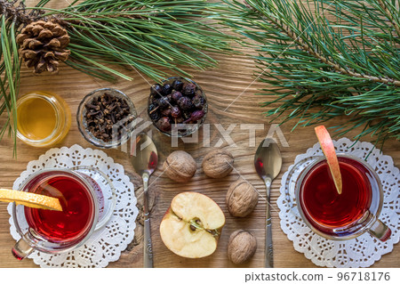 Two glass of mulled wine with cinnamon sticks, slice of oranges and apple, star anise on a wooden table 96718176