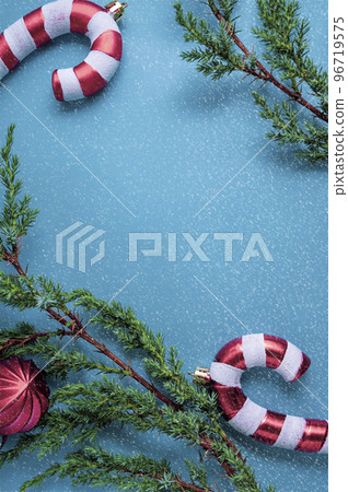 Christmas background. Fir tree branches, seasonal ornaments candy canes, stars. Creative blue flat lay, top view copy space 96719575
