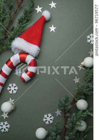 Christmas green background. Fir tree branches, seasonal ornament candy canes. Creative flat lay, top view copy space 96719577