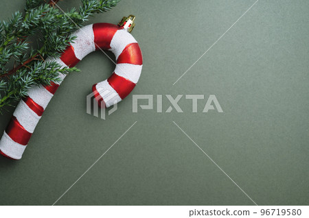 Christmas green background. Fir tree branches, seasonal ornament candy canes. Creative flat lay, top view copy space Christmas green background. Fir tree branches, seasonal ornament candy canes. Creative flat lay, top view copy space 96719580