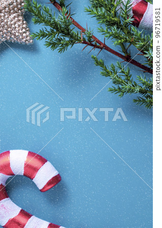 Christmas background. Fir tree branches, seasonal ornaments candy canes, stars. Creative blue flat lay, top view copy space Christmas background. Fir tree branches, seasonal ornaments candy canes, stars. Creative blue flat lay, top view copy space 96719581
