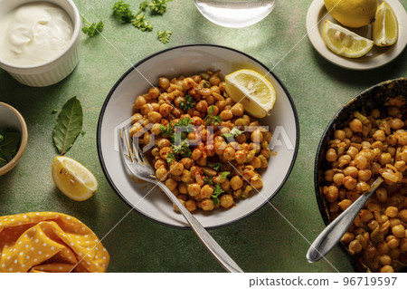 Cooked Chickpea dish with curry and spices, homemade vegan chickpeas, healthy food, colorful green background Cooked Chickpea dish with curry and spices, homemade vegan chickpeas, healthy food, colorful green background 96719597