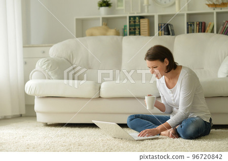 Portrait of a beautiful woman with a laptop on the floor 96720842