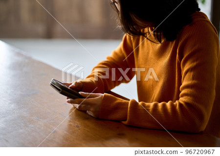 A woman who feels depressed looking at her smartphone 96720967