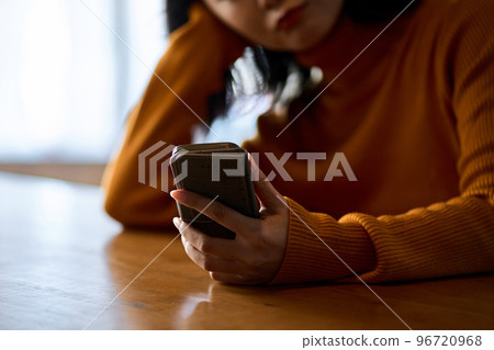 A woman who feels irritated by looking at her smartphone 96720968