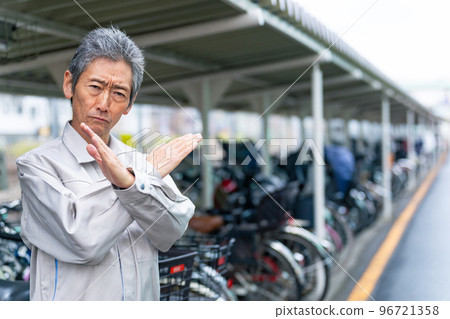 一位在自行車停車場展示十字標記的管理員高級男士 96721358