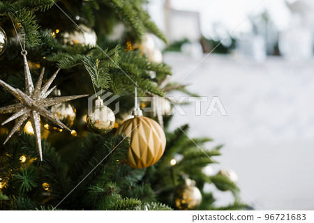 Fir branch with balls and festive lights on the Christmas background with sparkles. Fir branch with balls and festive lights on the Christmas background with sparkles. 96721683