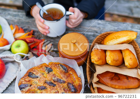 picnic in the autumn season, food on a wooden table, hot tea, pastries and sandwiches 96722231