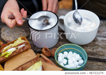 picnic in the autumn season, food on a wooden table, hot tea, pastries and sandwiches 96722274