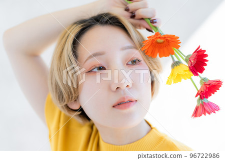 Portrait of young woman holding gerbera 96722986