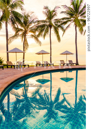 Umbrella and chair around swimming pool in resort hotel for leisure travel and vacation neary sea ocean beach 96722997