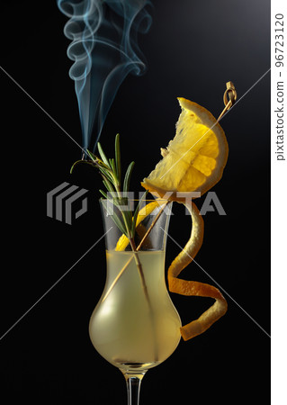 Limoncello garnished with a steaming rosemary branch. 96723120
