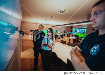 Group of Security data center operators working in a CCTV monitoring room looking on multiple monitors Officers Monitoring Multiple Screens for Suspicious Activities Team working on the System Contr Group of Security data center operators working in a CCTV monitoring room looking on multiple monitors Officers Monitoring Multiple Screens for Suspicious Activities Team working on the System Contr 96723146