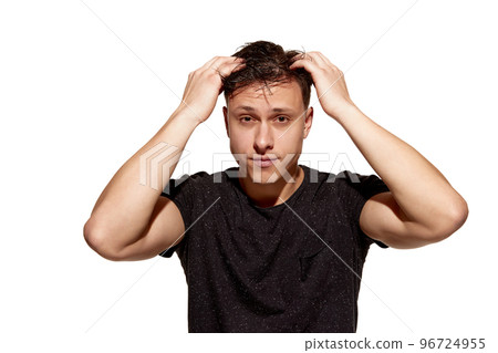 Young handsome man in casual T-shirt combs his hair with hands. Well-being. Concept of men's health, body and hair care Young handsome man in casual T-shirt combs his hair with hands. Well-being. Concept of men's health, body and hair care 96724955