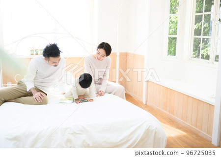 Family relaxing in the bedroom with copy space Family relaxing in the bedroom with copy space 96725035