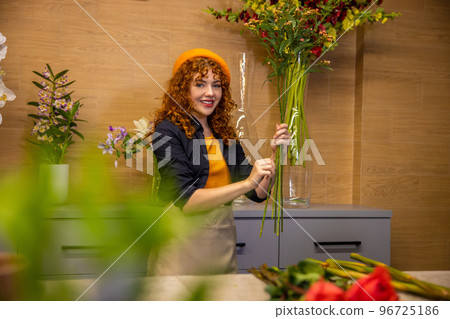 Ginger girl sorting flowers and looking contented 96725186