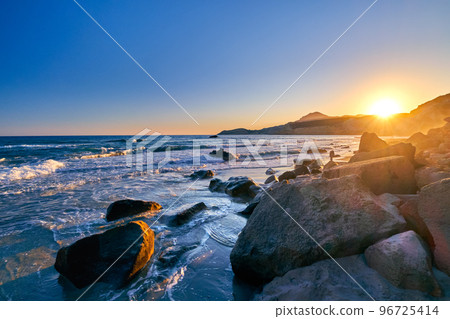 Colorful sunset on Fyriplaka beach, Milos, Greece. No people, low sun, wet stones, high tide, beautiful image  96725414