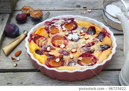 Damson blue plum clafoutis (flan), icing sugar and almonds dressing 96725622