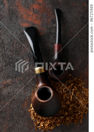 Smoking pipes with tobacco on dark textured background 96725989