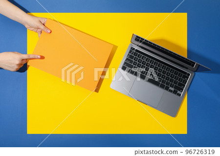 Laptop and female hands with space for text on yellow blue background 96726319