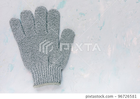 Exfoliating massage glove for shower on blue background, copy space. Bath, spa and cellulite treatment concept Exfoliating massage glove for shower on blue background, copy space. Bath, spa and cellulite treatment concept 96726581