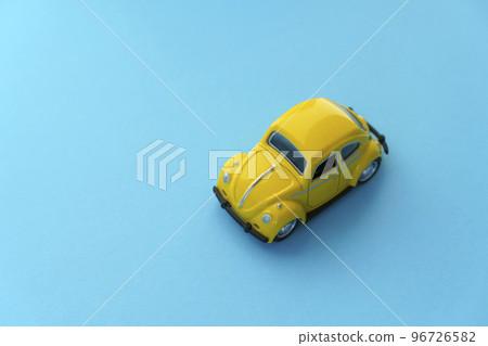 Travel car concept background. Yellow toy car on empty minimal pastel background. Driving, riding, road idea Travel car concept background. Yellow toy car on empty minimal pastel background. Driving, riding, road idea 96726582