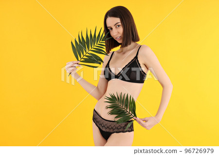 Concept of beauty with slim young woman on yellow background 96726979