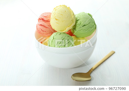 Bowl with ice cream scoops on white wooden table 96727090