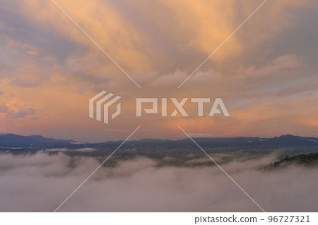 aerial view beautiful yellow sunrise above the mountain in phang Nga valley. slow floating fog blowing cover on the mountain look like as a sea of mist. scenery golden sunrise at horizon background. aerial view beautiful yellow sunrise above the mountain in phang Nga valley. slow floating fog blowing cover on the mountain look like as a sea of mist. scenery golden sunrise at horizon background. 96727321