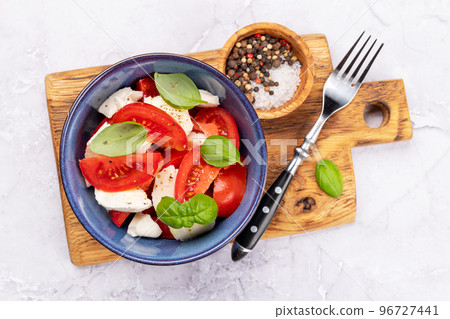 Caprese salad with ripe tomatoes, mozzarella cheese and garden basil Caprese salad with ripe tomatoes, mozzarella cheese and garden basil 96727441