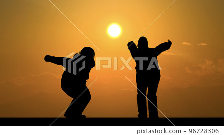 即將飛翔的兩人剪影_夕陽背景寬 即將飛翔的兩人剪影_夕陽背景寬 96728306