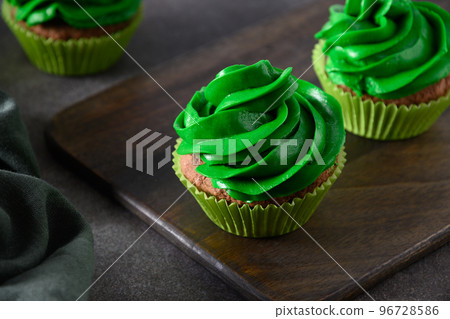 Chocolate cupcakes with green whipped cream and chocolate sprinkles. Chocolate cupcakes with green whipped cream and chocolate sprinkles. 96728586