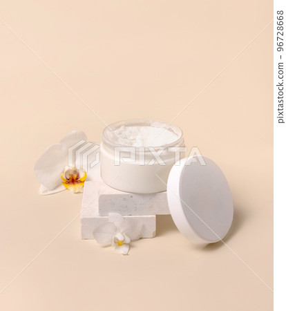 Opened Cream jar with a blank lid near orchid flowers on light yellow close up. Cosmetic Mockup Opened Cream jar with a blank lid near orchid flowers on light yellow close up. Cosmetic Mockup 96728668