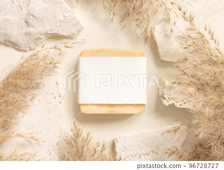 Soap bar with blank label near beige stones and dried pampas grass top view, mockup 96728727