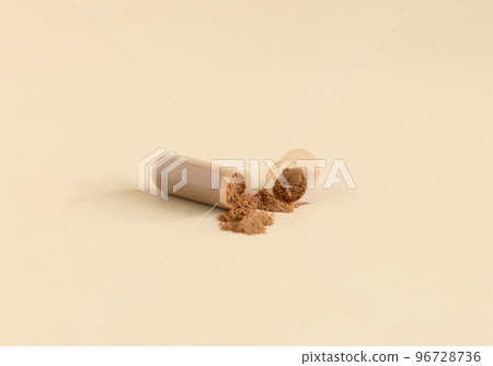 Opened Medical capsule to show brown powder on light beige close up. Dietary supplements Opened Medical capsule to show brown powder on light beige close up. Dietary supplements 96728736