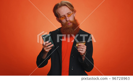 Young man using credit bank card and smartphone while transferring money, purchases online shopping Young man using credit bank card and smartphone while transferring money, purchases online shopping 96728963
