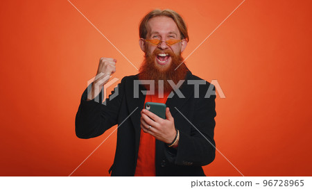 Happy excited man use mobile phone say wow yes found out great big win news doing winner gesture Happy excited man use mobile phone say wow yes found out great big win news doing winner gesture 96728965