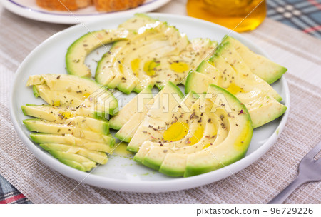 ripe avocado pulp cut into pieces sprinkled with lemon juice on a plate 96729226