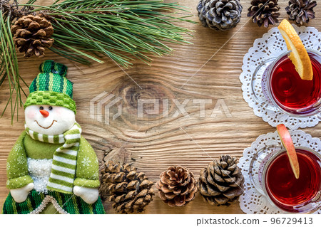 Hot mulled wine with spices on wooden background. Christmas tree branches, gifts and cones. 96729413