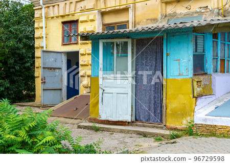 the entrance to an old house, weathered paint on the walls, an open wooden door with a curtain, the first floor of a city house, a view from the street the entrance to an old house, weathered paint on the walls, an open wooden door with a curtain, the first floor of a city house, a view from the street 96729598