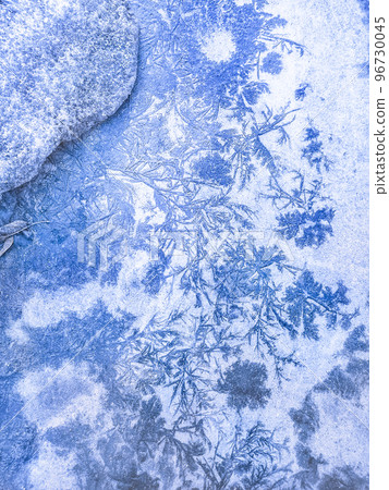 Frosty patterns on asphalt in the form of blue trees and ice flowers. Abstraction, winter background. Christmas Wallpaper. Frosty patterns on asphalt in the form of blue trees and ice flowers. Abstraction, winter background. Christmas Wallpaper. 96730045