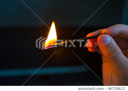 hand with burning match on black hand with burning match on black 96730622
