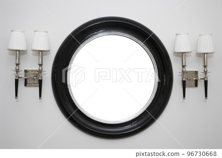 Mirror and lamps on a light white wall Mirror and lamps on a light white wall 96730668