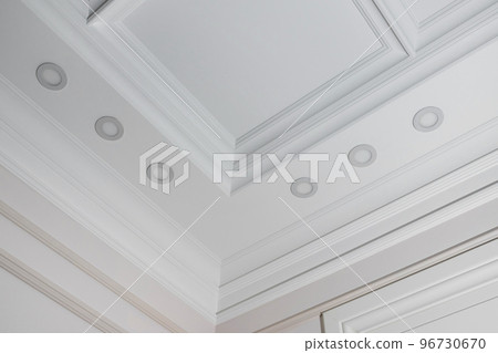 Ceiling moldings in the interior, detail of a angular ceiling skirting and lamps Ceiling moldings in the interior, detail of a angular ceiling skirting and lamps 96730670